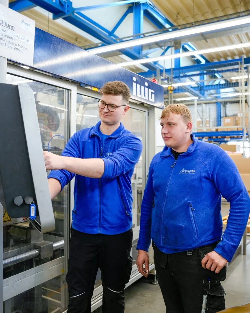Zwei Auszubildende an der Steuerung einer Thermoformanlage