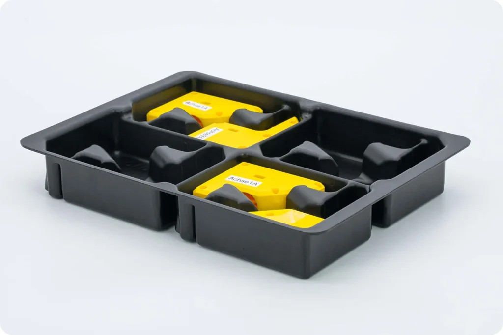 Schwarze Einlage mit geformten Nestern, darin gelbe Baugruppen mit Beschriftung