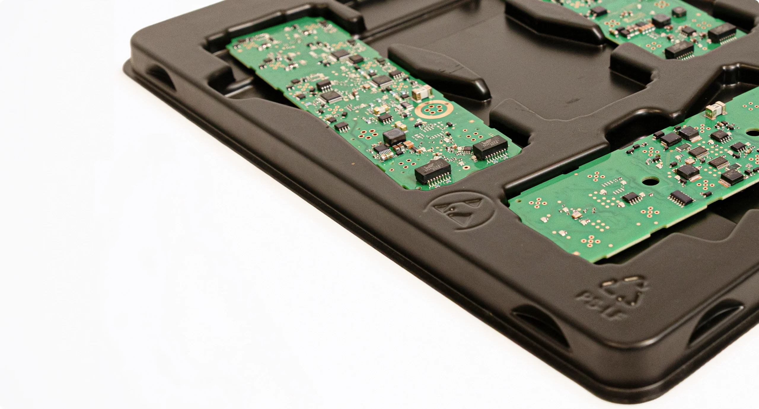 Schwarzes ESD-Tray mit bestückten Leiterplatten in passgenauen Nestern